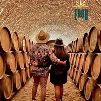 Pareja caminando entre barricas de tequila